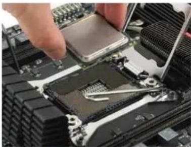 Close-up of hands installing a CPU into a motherboard with visible cooling tools (no text or symbols)