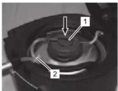 Technical diagram of a mechanical component with labeled parts 1 and 2, showing internal structure and directional arrows.