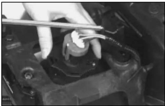 Close-up of a gloved hand using a tool to adjust or install a mechanical component (no visible text or symbols)