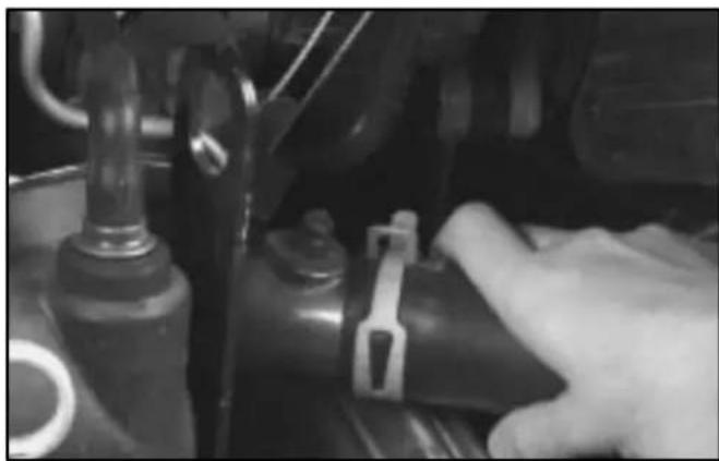 Close-up of a hand adjusting a mechanical component with a blue clip (no visible text or symbols)