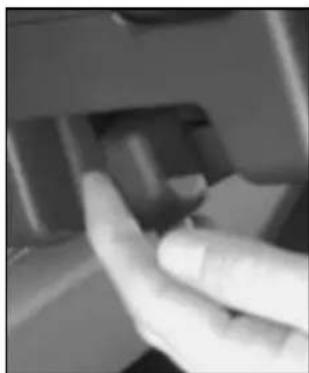 Close-up of a hand pressing a button on a mechanical component (no visible text or symbols)