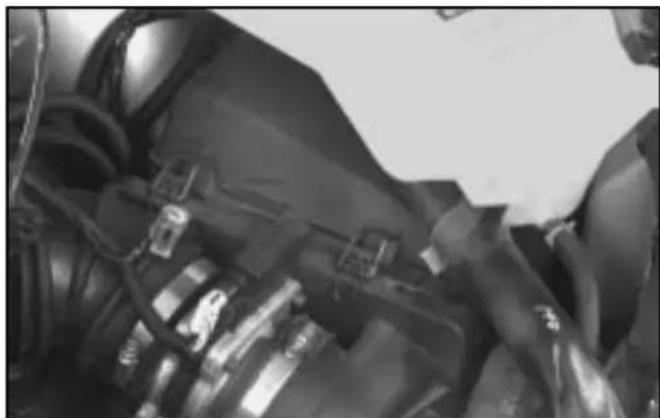 Close-up of a mechanical component with attached clamps and bolts (no visible text or symbols)