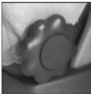 Close-up of a textured, circular object with a central dark circle, possibly a mechanical or electronic component (no visible text or symbols)
