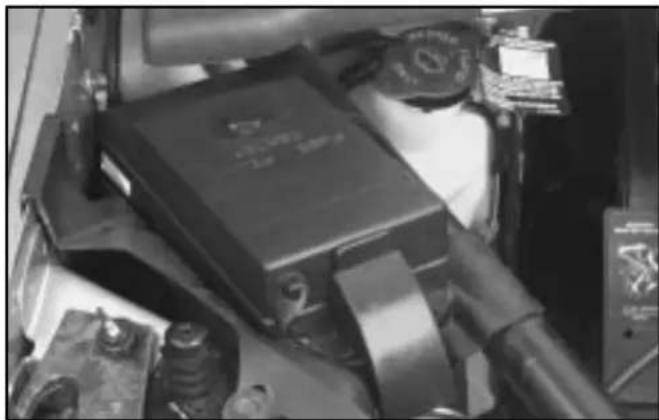 Black-and-white photo of a hand holding a large electronic device with visible components and no readable text or symbols.