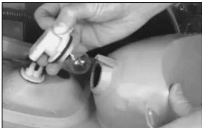 Close-up of hands adjusting a mechanical component with a tool (no visible text or symbols)