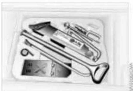 Assorted office supplies including pens, tools, and a tablet in a white tray (no visible text or labels)