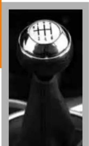 Close-up of a metallic gear shift lever with a circular head and central hub (no text or symbols visible)