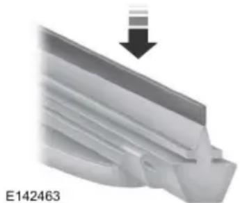 Close-up of a metallic mechanical component with a downward arrow indicating compression or dislocation (no text or symbols)