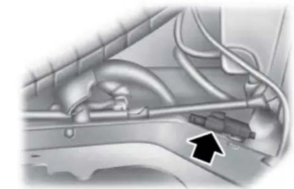 Close-up of a car's internal components with visible hoses and a black arrow pointing to a component (no text or symbols)
