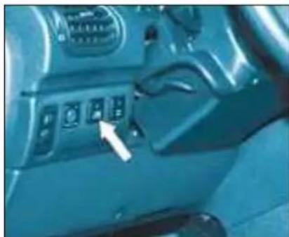 Interior view of a car dashboard with control panel and directional arrow (no visible text or symbols)