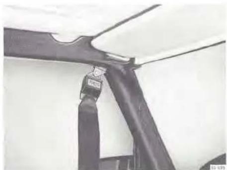 Close-up of a black mechanical component with a small attached bracket, mounted on a white wall (no visible text or symbols)