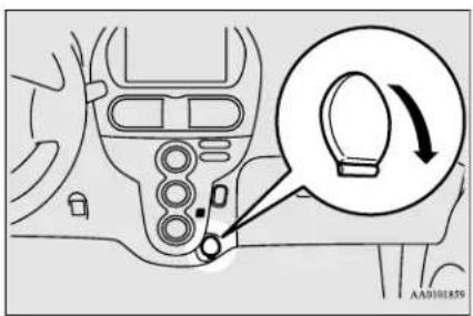 Diagram showing car interior control panel with a magnified circular detail highlighting the steering wheel's rotation direction.