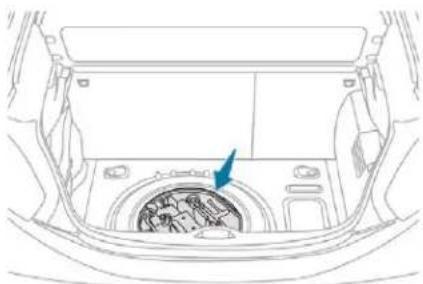 Line drawing of a car interior showing the dashboard and engine compartment with a blue arrow pointing to a component (no text or symbols)