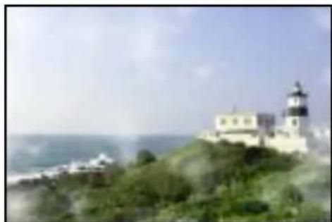 Coastal view of a lighthouse on a hilltop with ocean and misty sky in the background (no visible text or symbols)