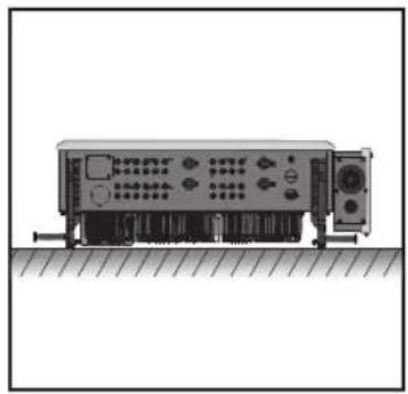 Front view of a mechanical or electronic device with ports and connectors, resting on a surface (no visible text or symbols)