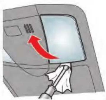 Diagram showing a hand holding a tool interacting with a device panel, with a red arrow indicating direction or movement.