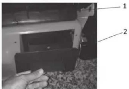 Close-up photo of a hand holding a black plastic device with labeled parts 1 and 2