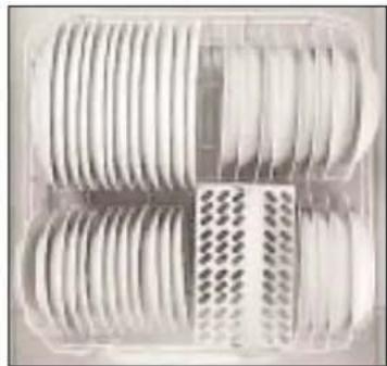 Close-up of a transparent plastic container with multiple circular white objects arranged in rows (no visible text or symbols)