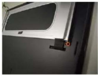 Close-up of a metallic door with a small handle and a rectangular opening, showing no visible text or symbols.