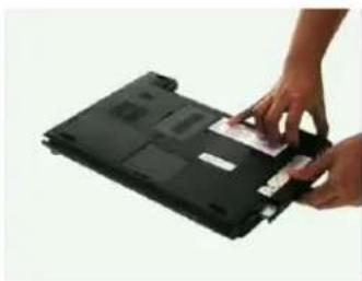 Close-up of hands installing a card into a black electronic device (no visible text or symbols)