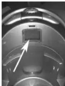 Close-up of a mechanical component with a white arrow pointing to a small rectangular feature (no visible text or symbols)