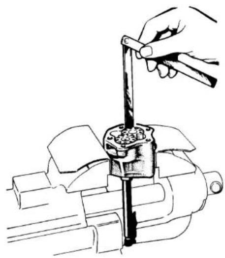 Line drawing of a hand using a tool to adjust or install a mechanical component (no text or symbols present)