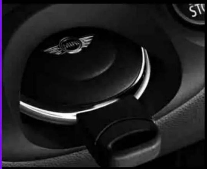Close-up of a car's seatbelt with a circular emblem on the lid (no visible text or symbols)