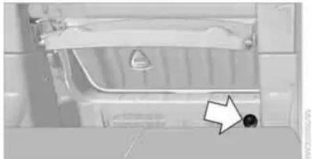 Close-up of a car's front bumper with a white arrow pointing to a small black dot on the side (no text or symbols visible)