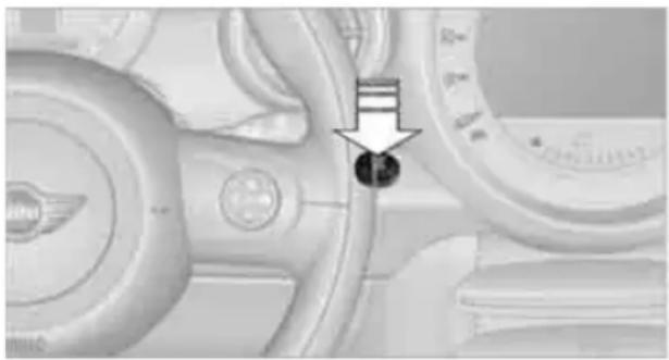 Close-up of a car dashboard with a black arrow pointing to a circular component (no visible text or symbols)