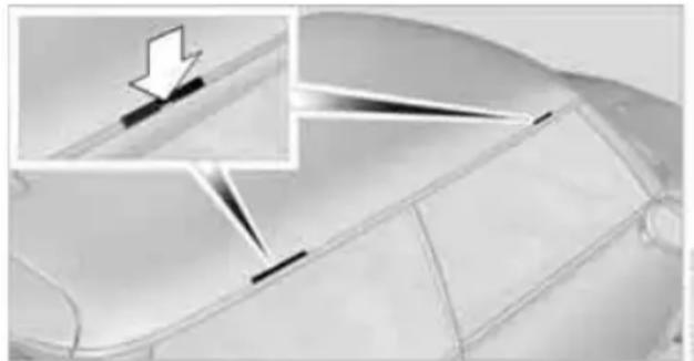 Close-up of a car's side panel with a magnified inset showing a downward arrow (no text or symbols)