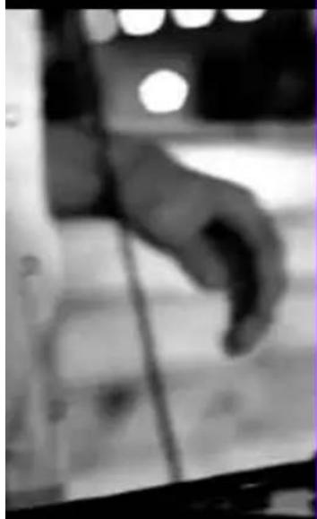 Black and white photo of a hand reaching toward a window, no visible text or symbols