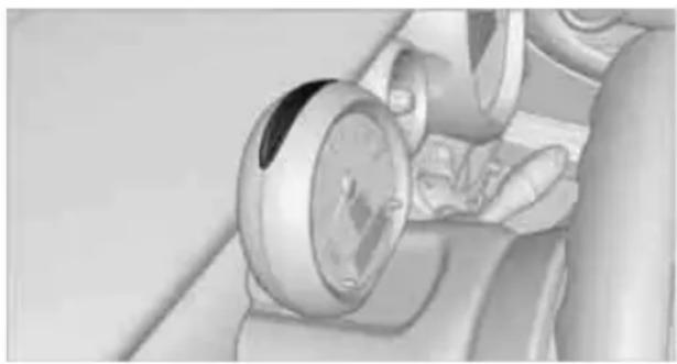 Close-up of a hand holding a circular gauge or dial, with no visible text or symbols