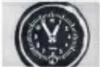 Close-up of a circular digital clock face with engraved numbers and symbols