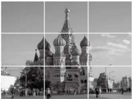 Black-and-white photo of St. Basil's Cathedral in Moscow, showing its iconic spires and surrounding urban street scene (no visible text or signage)