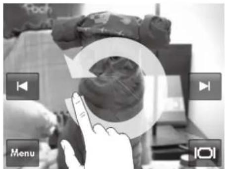 Black-and-white photo showing a hand interacting with a clothing item, overlaid with 'Menu' and 'IOI' icons and playback controls.