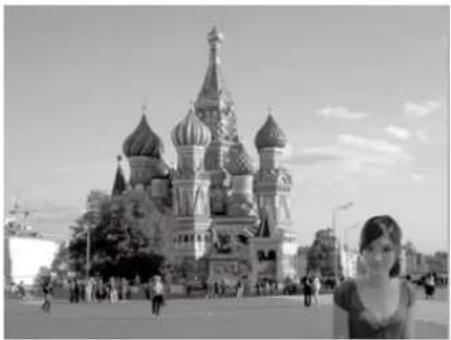 Black-and-white photo of St. Basil's Cathedral in Moscow, featuring the Saint Basil in the background with pedestrians and trees (no visible text or signage)