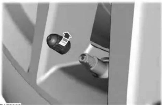 Close-up of a hand holding a small mechanical component with an arrow pointing to it (no visible text or symbols)