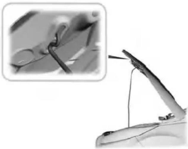 Close-up of a mechanical component with a close-up inset showing a wire being inserted (no text or symbols visible)
