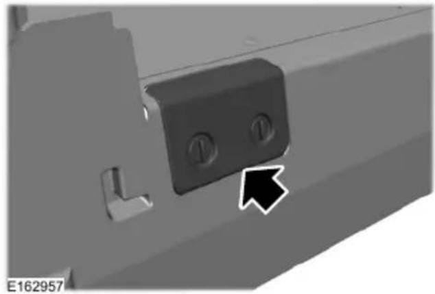Close-up of a mechanical component with two circular holes and a black arrow pointing to a feature (no text or symbols visible)