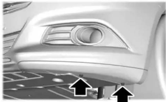 Close-up of a car's front wheel and dashboard area with two black arrows pointing to the side (no text or symbols visible)