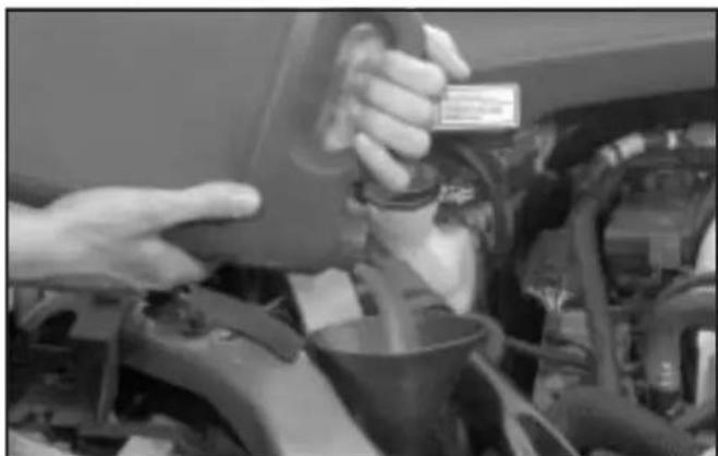 Close-up of hands inspecting a car engine compartment with visible engine and dashboard (no text or symbols)