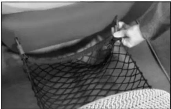 Close-up of a hand holding a mesh net over a surface, no visible text or symbols