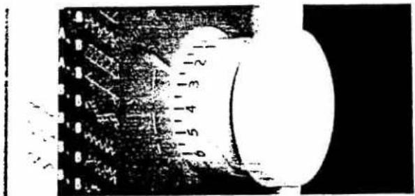 Black-and-white technical diagram showing a circular component with numbered parts and a scale bar, likely from an engineering or manufacturing context.
