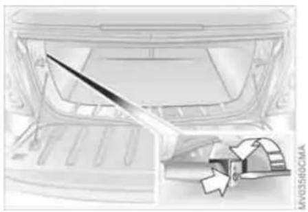 Technical illustration of a car rear bumper with a tool inserted, showing no text or symbols