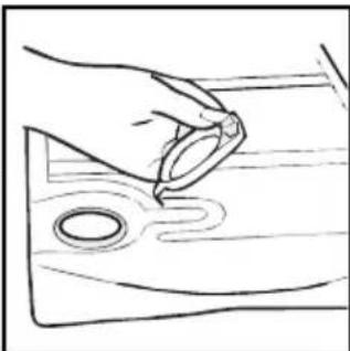Simple line drawing of a hand holding a ring above a wooden surface with a small circular hole (no text or symbols)