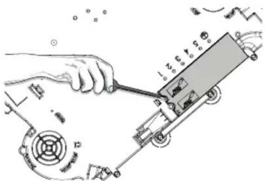 Technical diagram showing a hand using a tool to adjust or install a mechanical component with labeled parts and motion indicators.