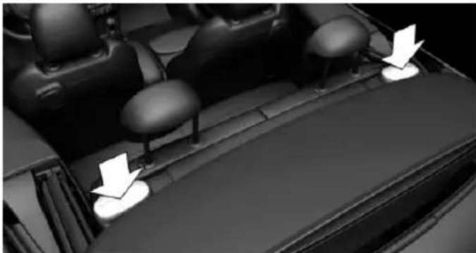 Interior view of a car showing seatbelt and dashboard with white arrows pointing to specific areas (no text or symbols visible)
