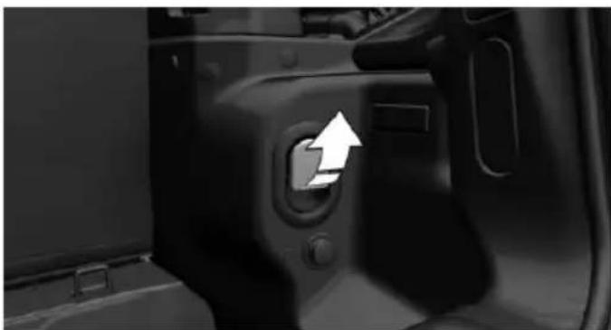 Close-up of a car door panel with a white arrow pointing to the left side of the door (no text or symbols visible)