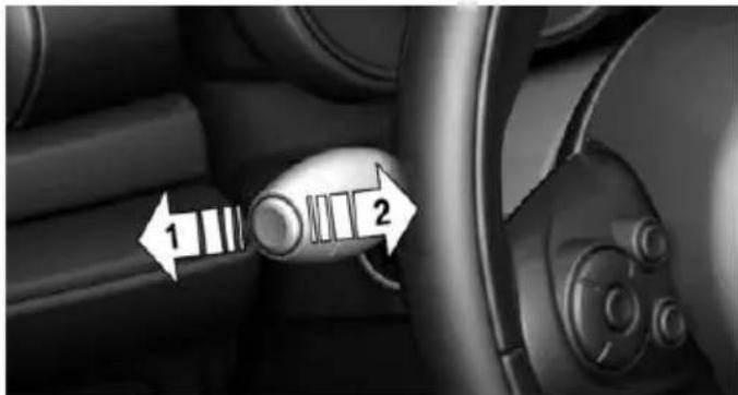 Interior view of a car showing a gear shift lever with numbered arrows (1 and 2) indicating direction, no text or symbols present.