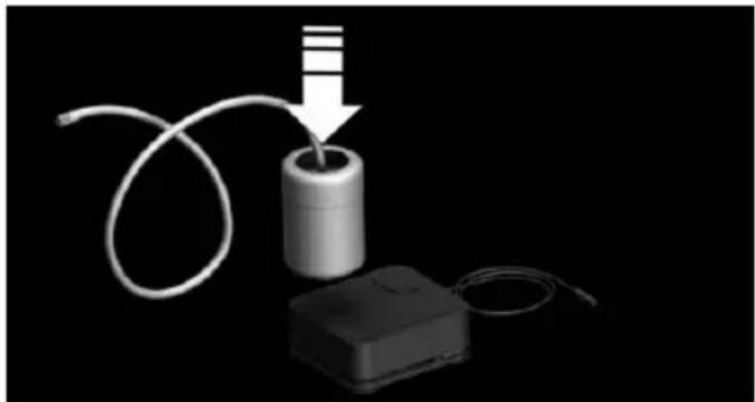 3D rendering of a cylindrical device with a wire being inserted into it, connected to a battery pack (no text or symbols visible)